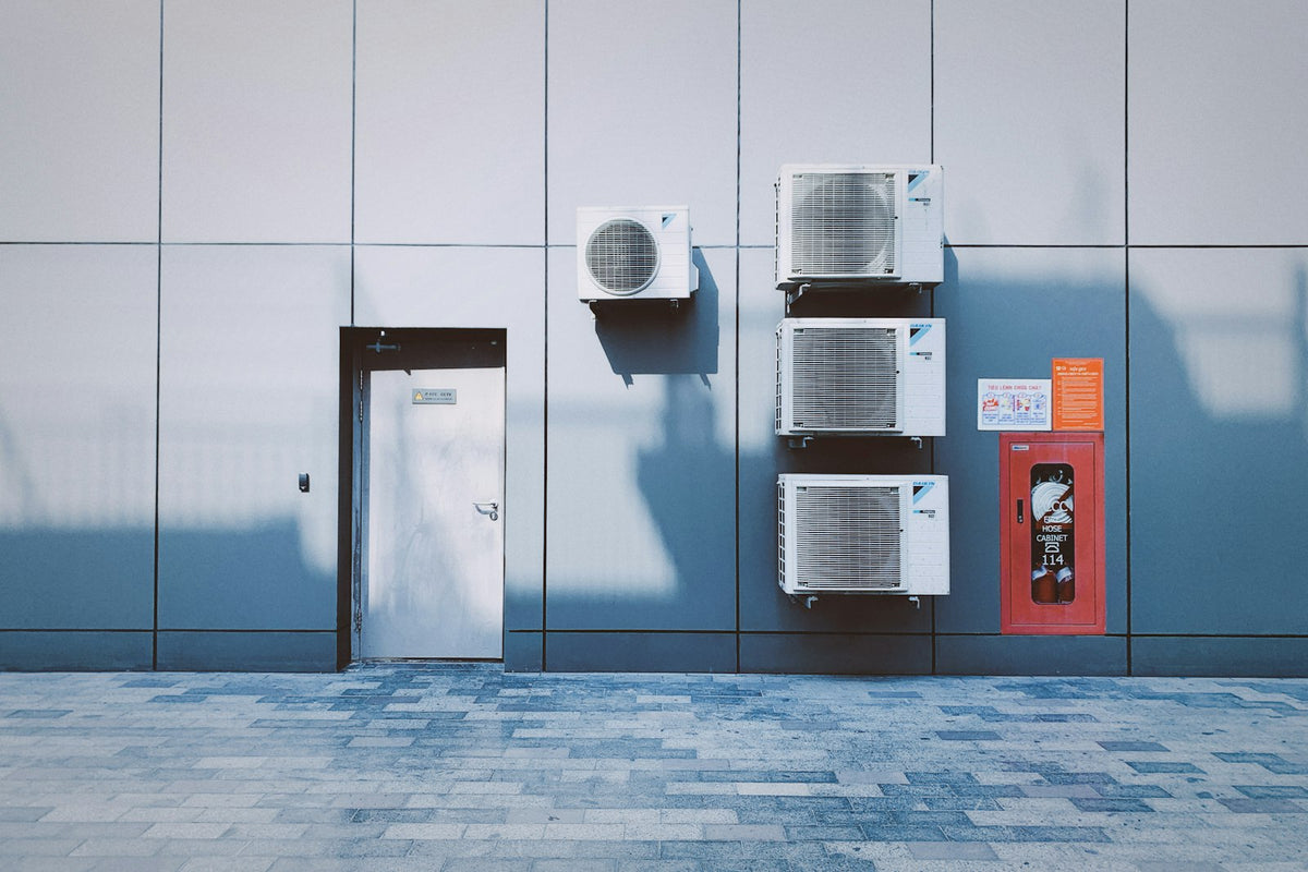 Row of packaged air conditioning units on a commercial building wall
